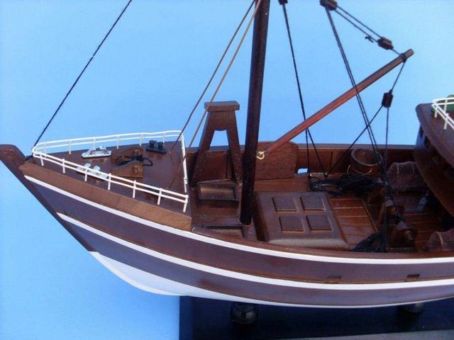 This wooden fishing boat model is attached to a sturdy wooden base